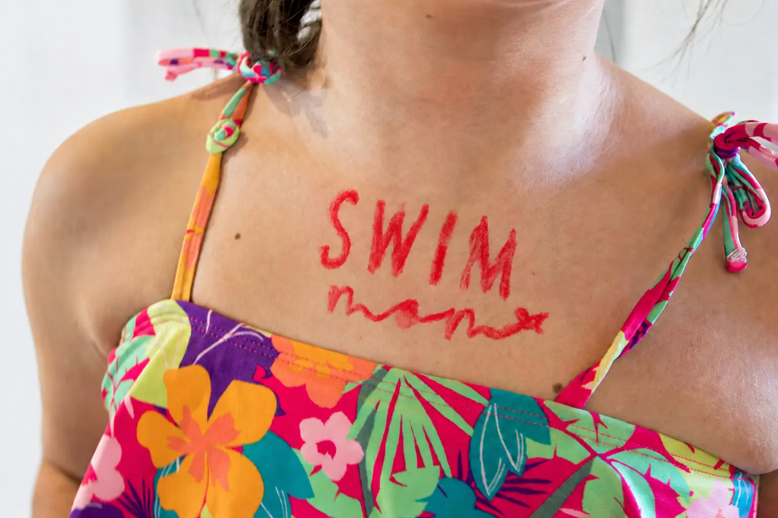 The word SWIM written brightly across a swimmer's upper chest